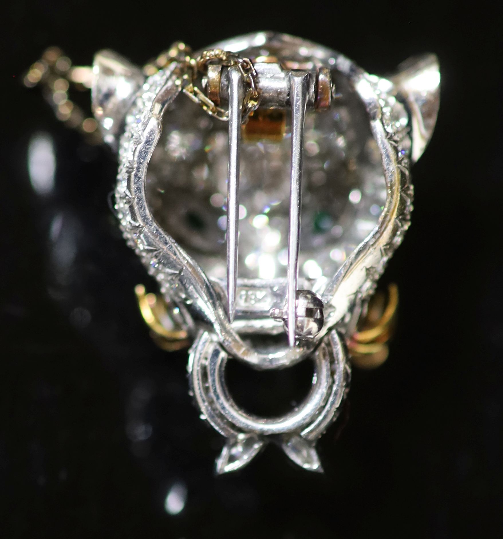 An 18K white gold and diamond leopard's head clip brooch, with emerald eyes, ruby nose and gold whiskers,